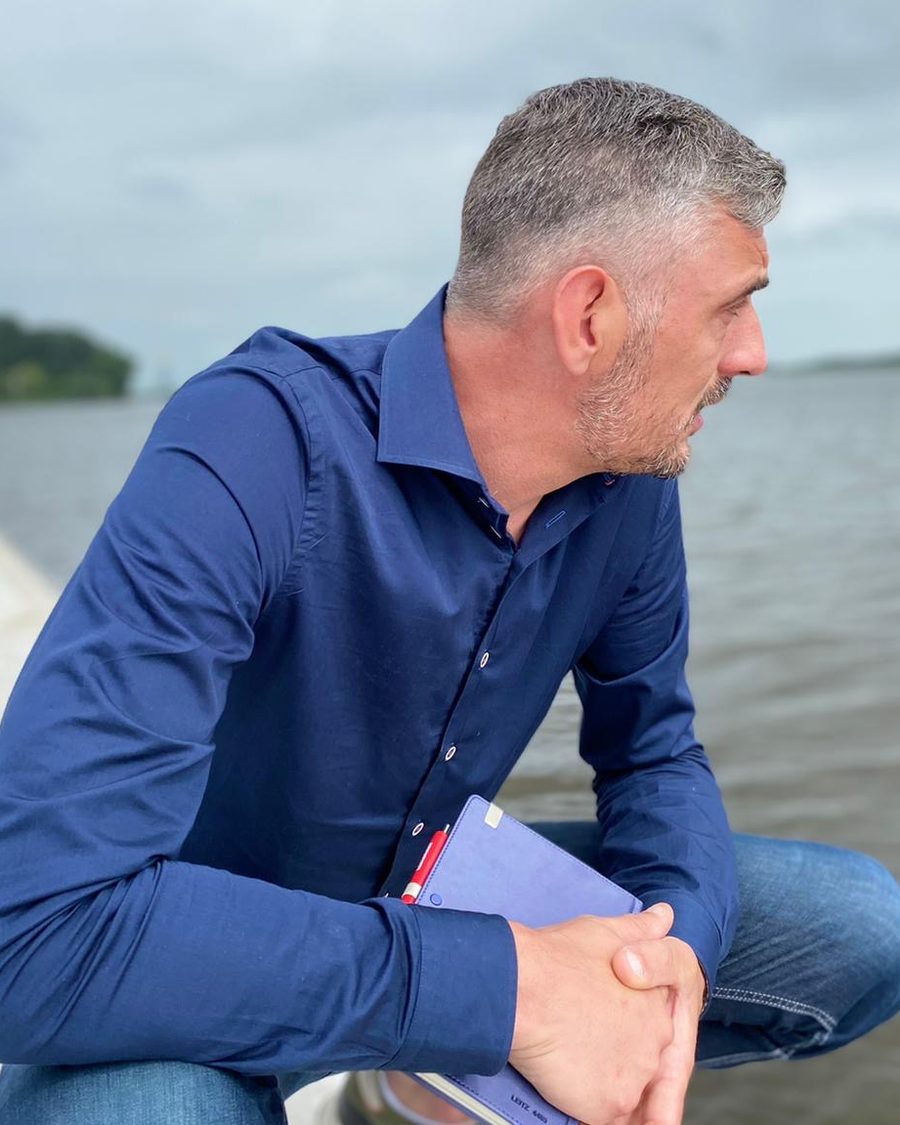 Pieter Smidt van Zorg-Coach, zittend aan het water met een notitieboek in zijn handen