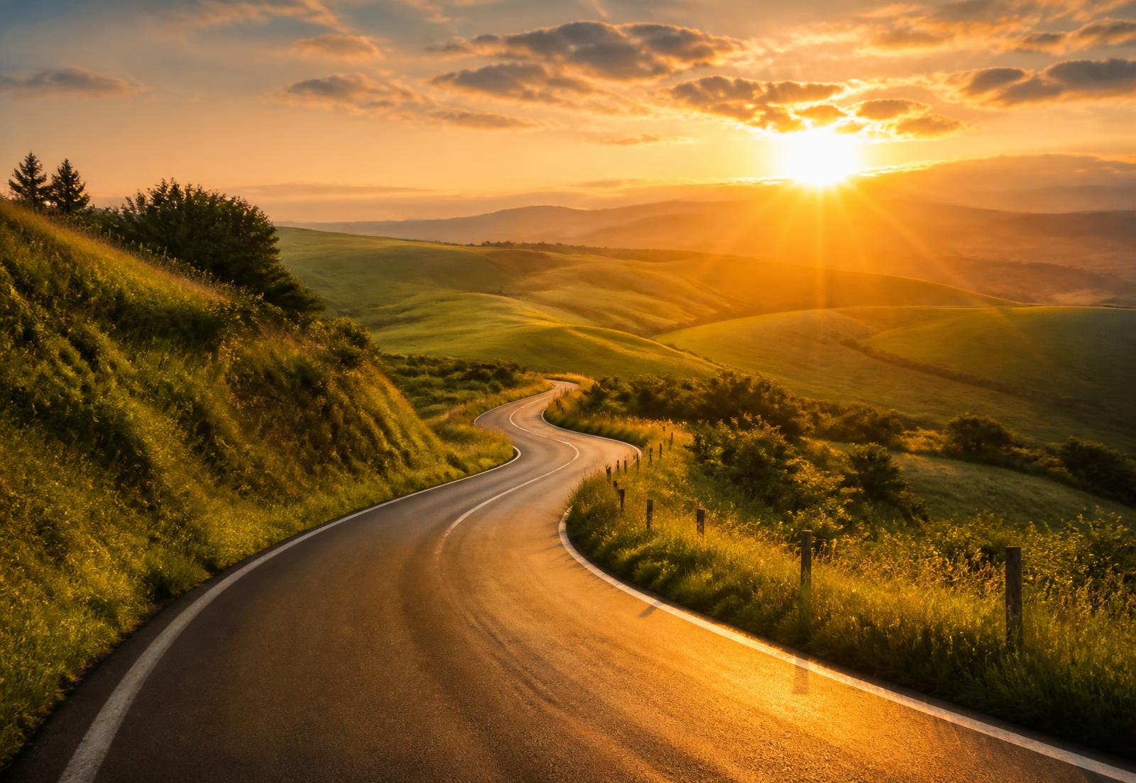 Kronkelende weg door groene heuvels naar een zonsopgang aan de horizon